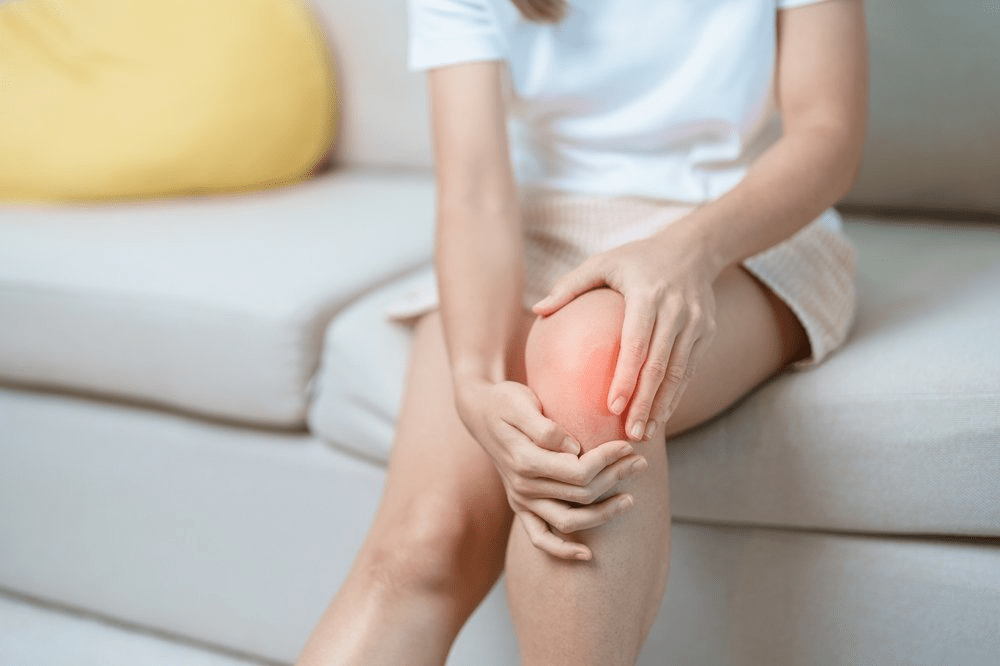 woman holding her knee that is causing her pain